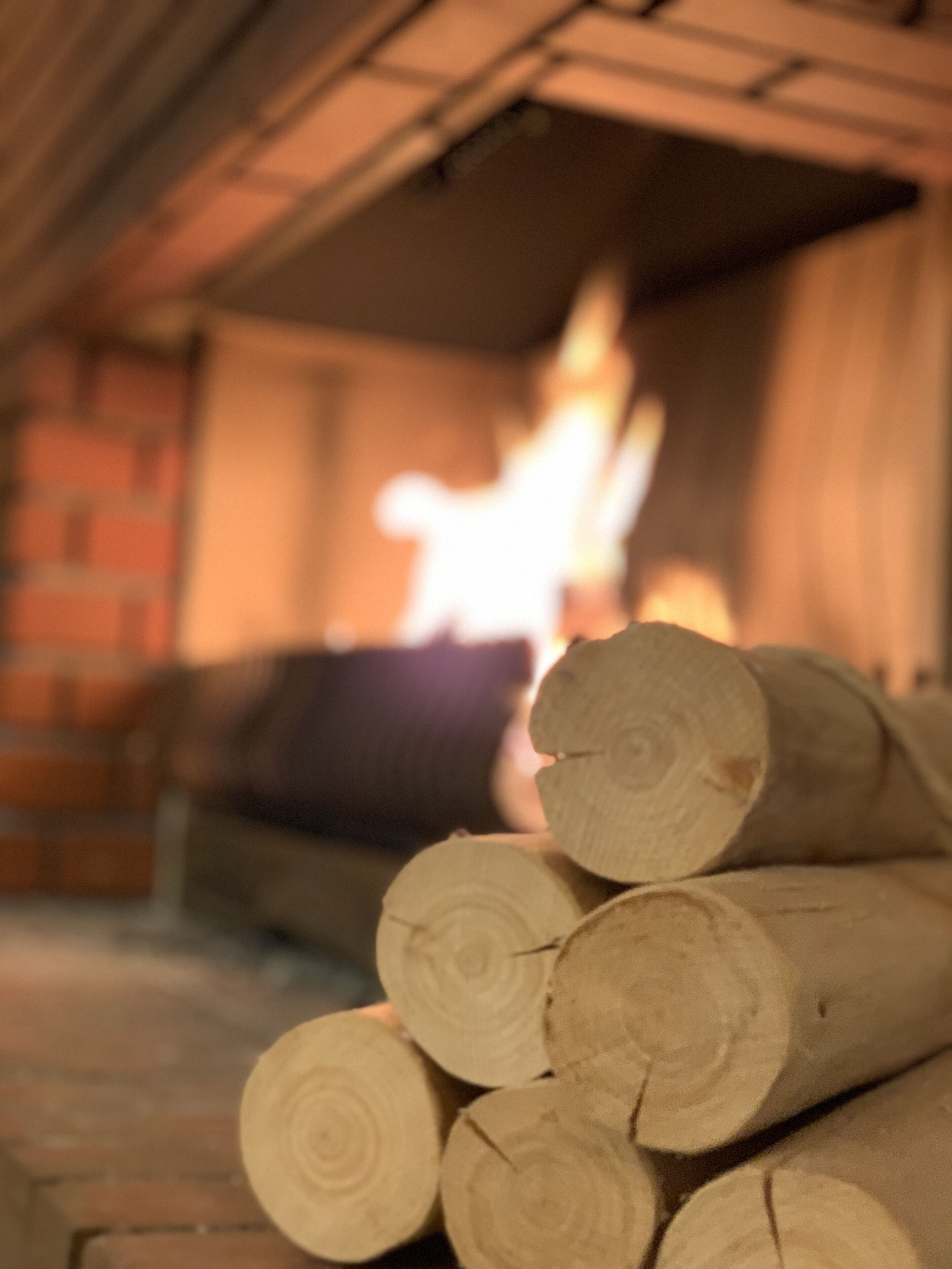 Ein Holzstoß im Kamin mit unscharfem Hintergrund.
