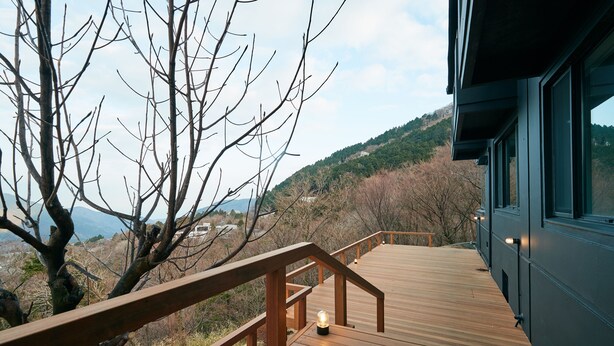 Eine Holzterrasse mit Geländer, mit Blick auf eine Berglandschaft.