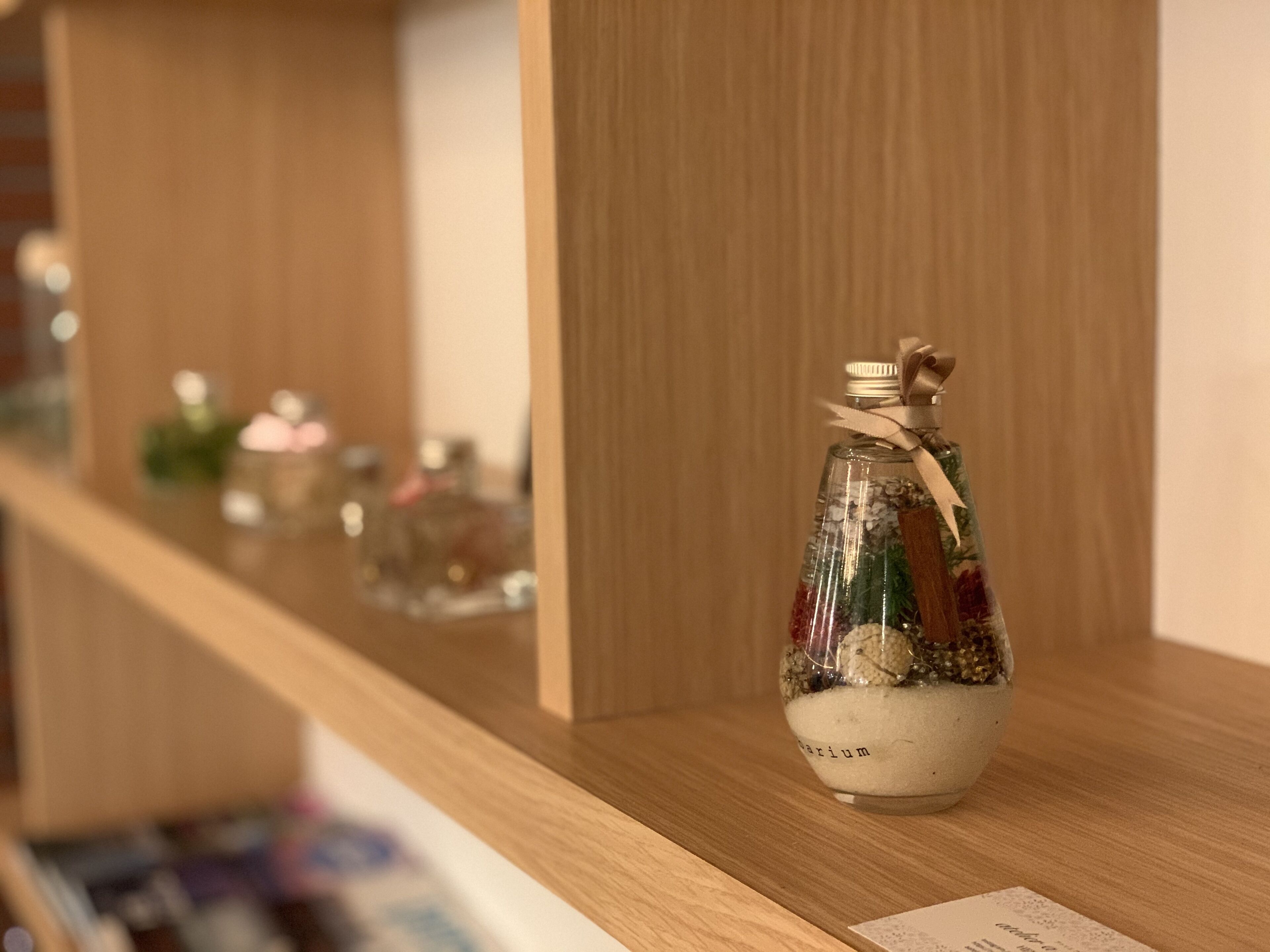 A shelf with various glass bottles containing different items.