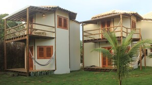 Two-story buildings with wooden balconies and a hammock. - Pousada Vila Cacau (Uruçuca)