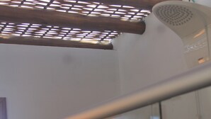 A glass railing with a view of a wooden structure outside. - Pousada Vila Cacau (Uruçuca)