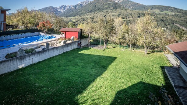 A backyard with a swimming pool, a red shed, and a view of mountains. - Casa Melissa (Schönberg im Stubaital)