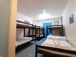 A dormitory room with bunk beds, a window with blue curtains, and a framed picture on the wall. - Daltans Home Stay (General Luna)