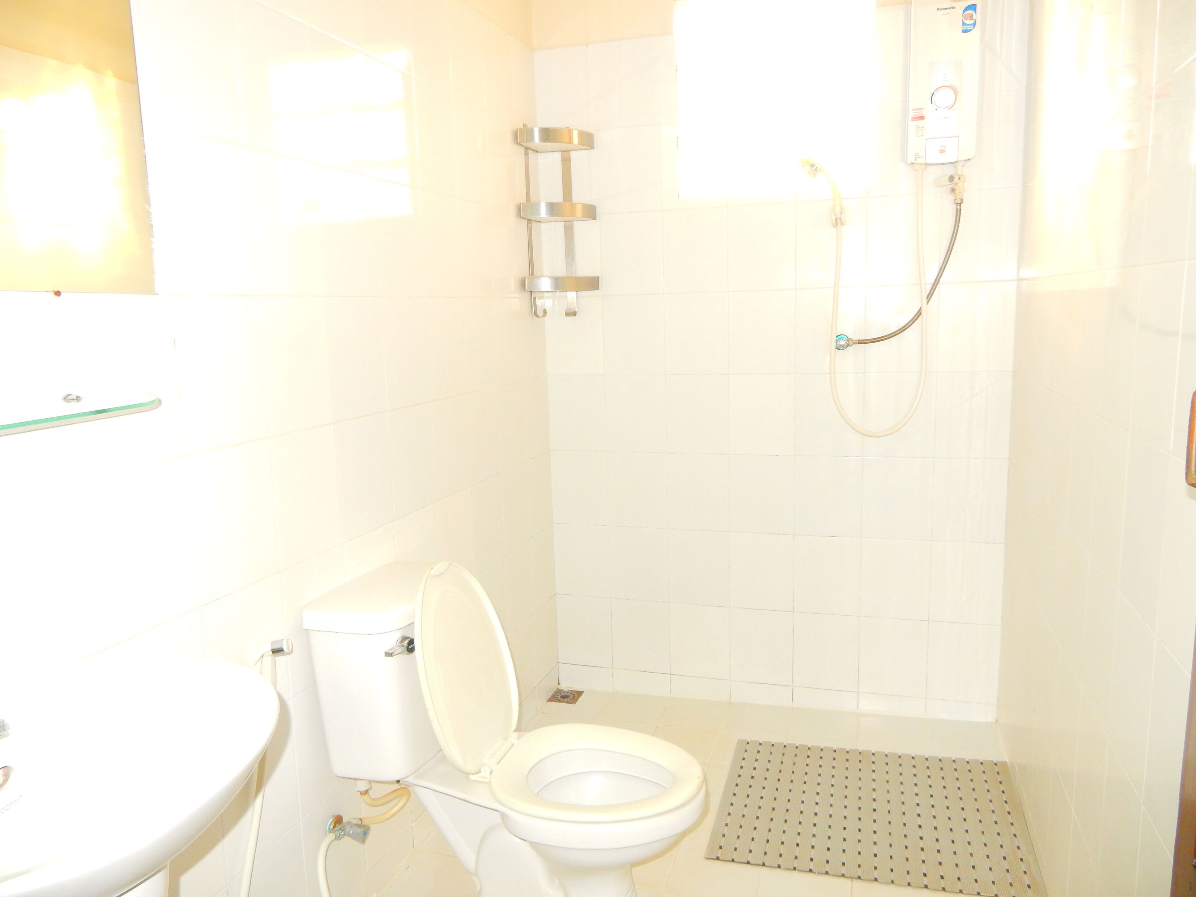 Un bagno con un water, una doccia e un lavandino.