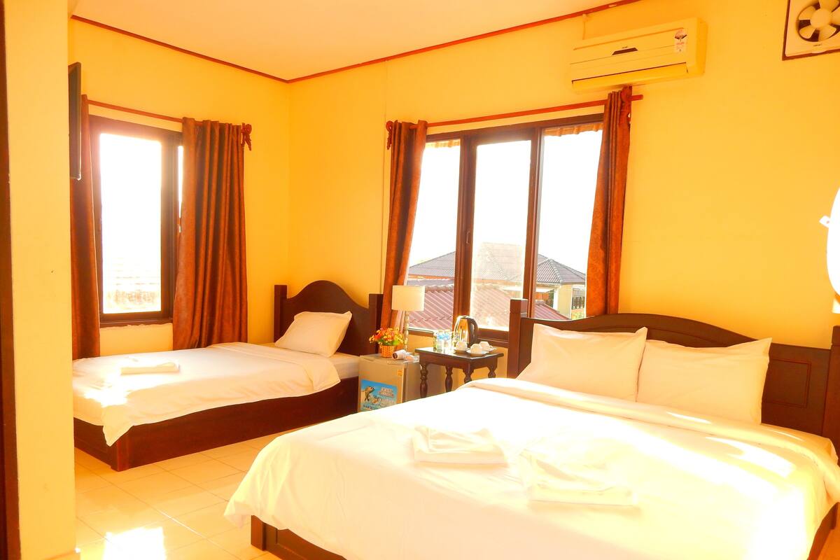 Une chambre d’hôtel avec deux lits, une table de chevet et un appareil de climatisation.