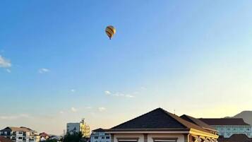 Un globo aerostático en el cielo sobre una zona residencial con edificios de varios pisos.