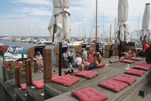 A marina with boats, outdoor seating, and umbrellas.