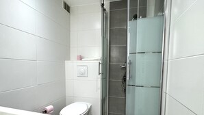 Ein modernes Badezimmer mit Toilette, Dusche und Waschbecken.