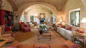 A cozy living room with a fireplace, comfortable seating, and a rustic brick ceiling. - Beautiful private villa for 16 guests with A/C, WIFI, private pool, TV, patio and panoramic view (Montalcino)