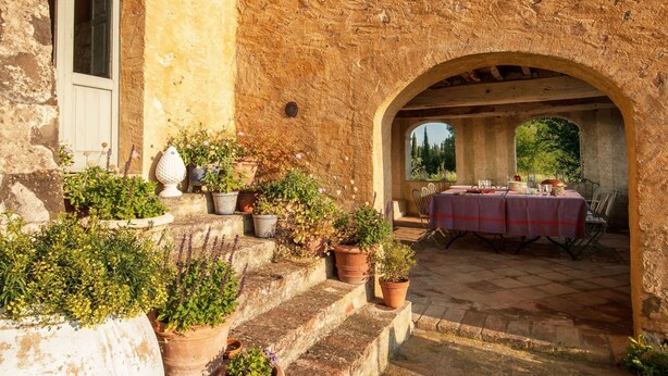 A stone building with a table set for dining under an archway. - Beautiful private villa for 16 guests with A/C, WIFI, private pool, TV, patio and panoramic view (Montalcino)