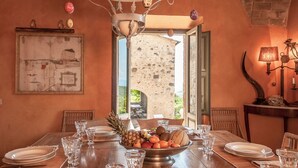 A dining table set with plates, glasses, and a fruit bowl. - Beautiful private villa for 16 guests with A/C, WIFI, private pool, TV, patio and panoramic view (Montalcino)