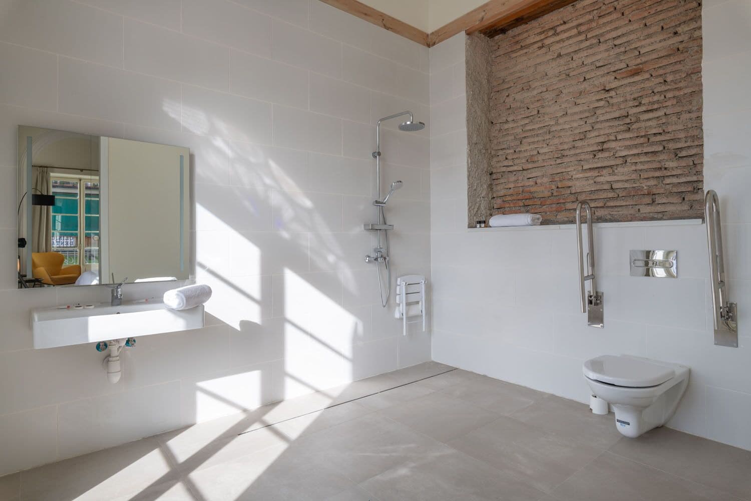 A modern bathroom with a white sink, a toilet, and a shower.