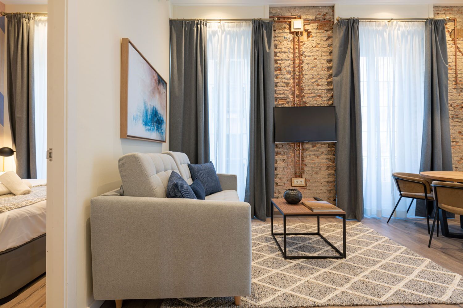 Una sala de estar moderna con un sofá, una mesita y un comedor.