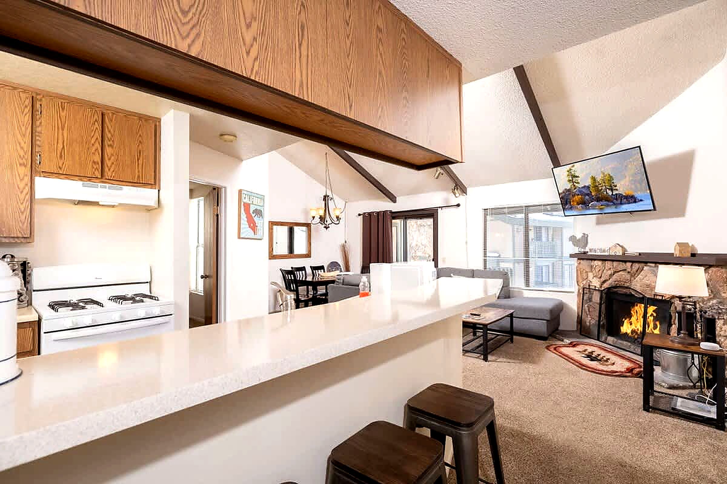 A modern kitchen with a white countertop, wooden cabinets, and a gas stove.