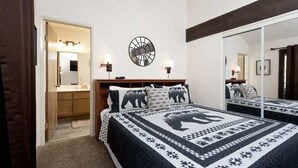 A bedroom with a large bed, a mirror, and a wall clock.