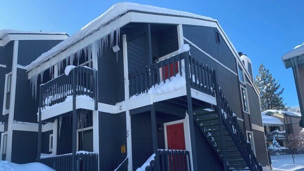 A multi-story building with a red door, a balcony, and a staircase. - Steps to Lake. Close to Village and Spa. Pool/Spa (Big Bear)