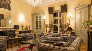 Un salon luxueux agrémenté d’un magnifique lustre, de canapés moelleux et d’une décoration classique.