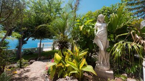 Une statue dans un jardin avec vue sur la mer.