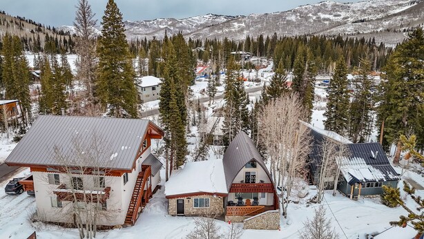 Un ensemble de chalets, avec en toile de fond une montagne enneigée, qui présente un mélange d’architecture moderne et traditionnelle.
