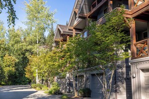 A residential building with multiple stories, a garage, and a driveway.