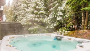 A hot tub surrounded by trees.