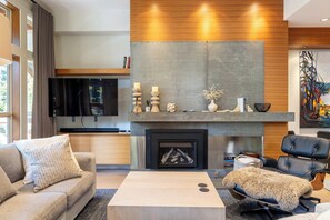 Una sala de estar moderna con chimenea, televisor de pantalla plana y un espacio de estar acogedor.