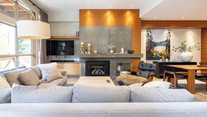 A modern living room with a sofa, fireplace, and artwork.