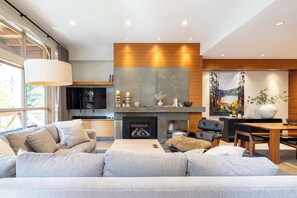 Una sala de estar moderna con sofá, chimenea y obras de arte.