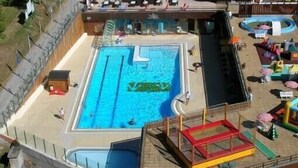 A swimming pool with a slide, a small play area, and lounge chairs. - Studio at the foot of the slopes, for 2 people. (Villarembert)