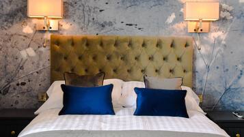 A neatly made bed with a tufted headboard, two bedside lamps, and a textured wall.