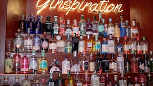 A wall of various liquor bottles with a neon sign that reads "Ginsengation". - The Strand Hotel, the former residence of Oscar Wilde (Bray)