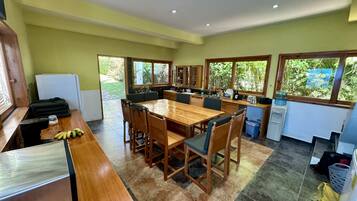 Una cocina amplia con una mesa de comedor de madera, sillas y un refrigerador.
