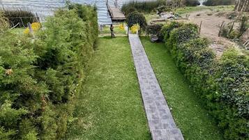 A pathway leading to a dock over a lake with mountains in the background.