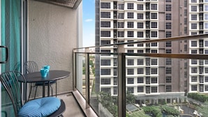 Ein Balkon mit Tisch und Stühlen mit Blick auf ein Wohngebiet mit Hochhäusern.