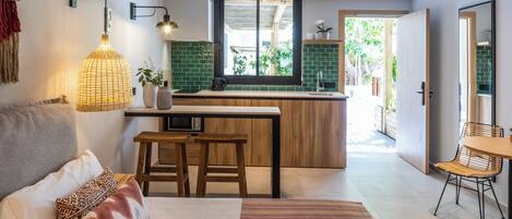 A modern kitchen with a central island, wooden stools, and a dining area with a table and chairs.