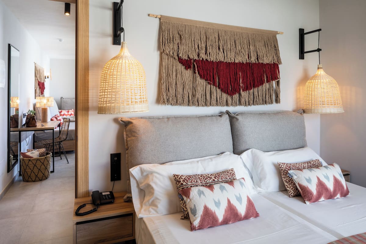 Une chambre d’hôtel moderne avec un grand lit, deux tables de chevet, un bureau et une chaise.