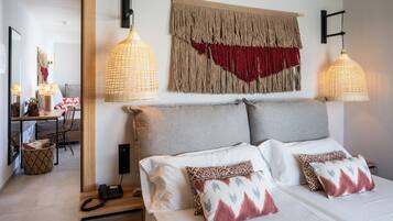 Een moderne hotelkamer met een groot bed, twee nachtkastjes, een bureau en een stoel.