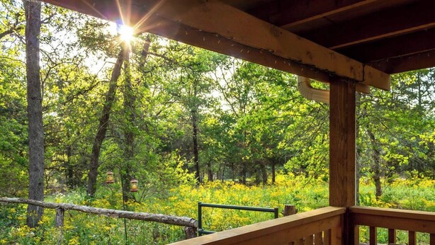 A wooden deck with a view of a forested area.