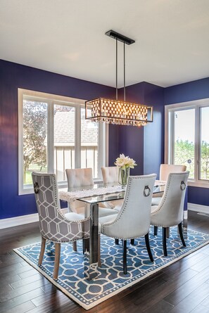 A dining area with a glass table, four upholstered chairs, a patterned rug, and a hanging light fixture. - GLOBALSTAY. Unique 5BR Villa. Swimming Pool. HOT TUB (Lincoln)