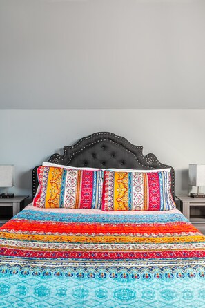 A bed with a black upholstered headboard and a colorful, patterned bedspread. - GLOBALSTAY. Unique 5BR Villa. Swimming Pool. HOT TUB (Lincoln)