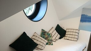 Een gezellige slaapkamer met een bed, kussens en een raam.