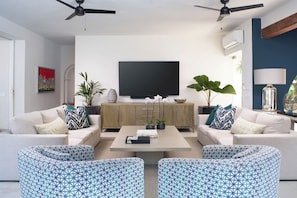 A modern living room with two sofas, a coffee table, and a flat-screen TV.
