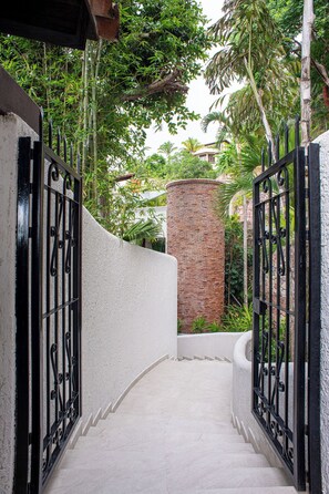 Una escalera de concreto que lleva a una entrada cerrada con un muro de ladrillo y puertas metálicas.