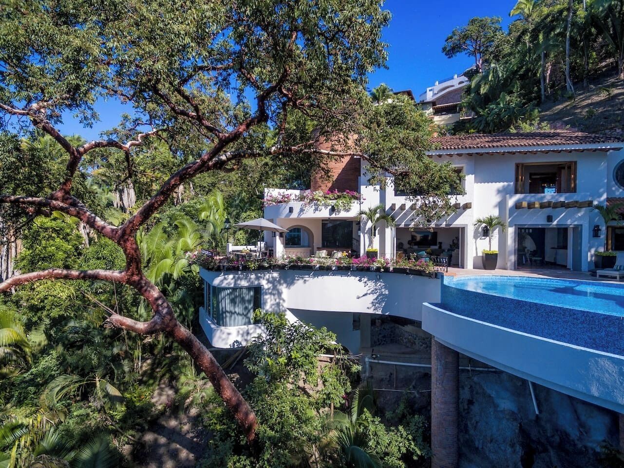 Un complexe hôtelier doté d’une piscine, d’un patio abrité et d’une végétation luxuriante.
