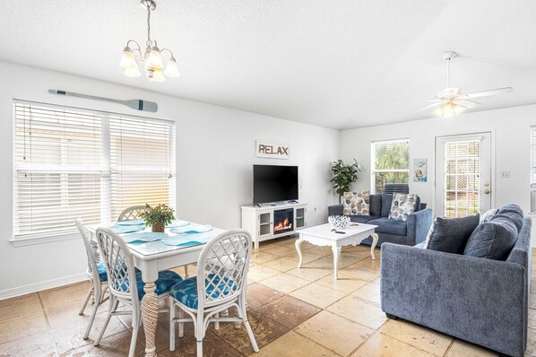 A spacious living room with a TV, seating area, and a fireplace.