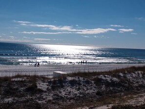 Una playa con arena en primer plano y cielo despejado.