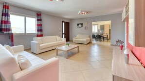 Un salon moderne comprenant un canapé, une table basse et un coin repas avec des chaises et une table.