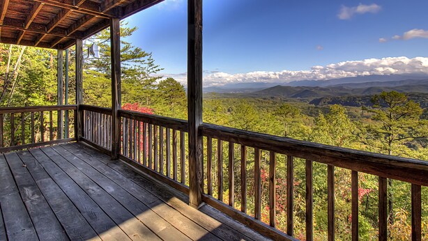 Une terrasse en bois offrant une vue sur un paysage montagneux.