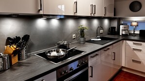 Una cocina moderna con electrodomésticos de acero inoxidable, un lavamanos y una cafetera.