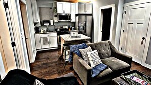 A modern living room with a grey sofa, a coffee table, and a TV stand. - Cozy Charming •Art 🎨 • Food🌮 Close to Train 🚉 • Parking! (Chicago)